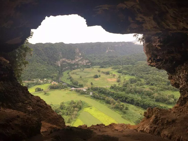 Panoramic cave opening overlooking fields