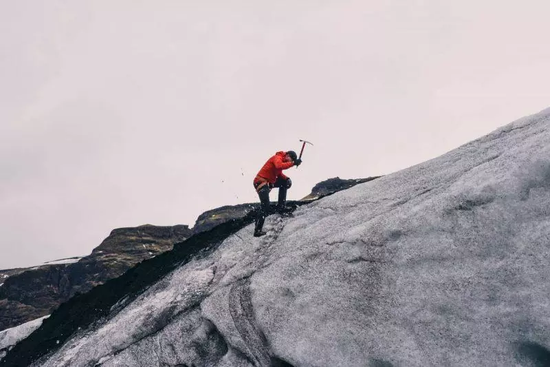 Man with ice pick on glacier