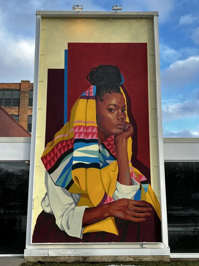 Mural of woman with scarf on side of a building