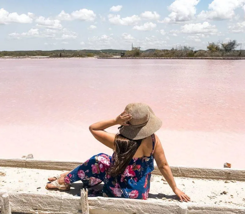 Woman sitting by pink lakes