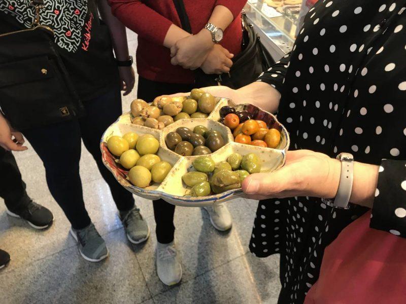 Woman holding a plate of olives