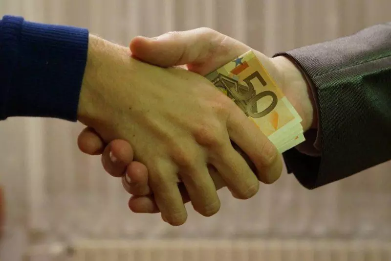 Money changing hands in handshake