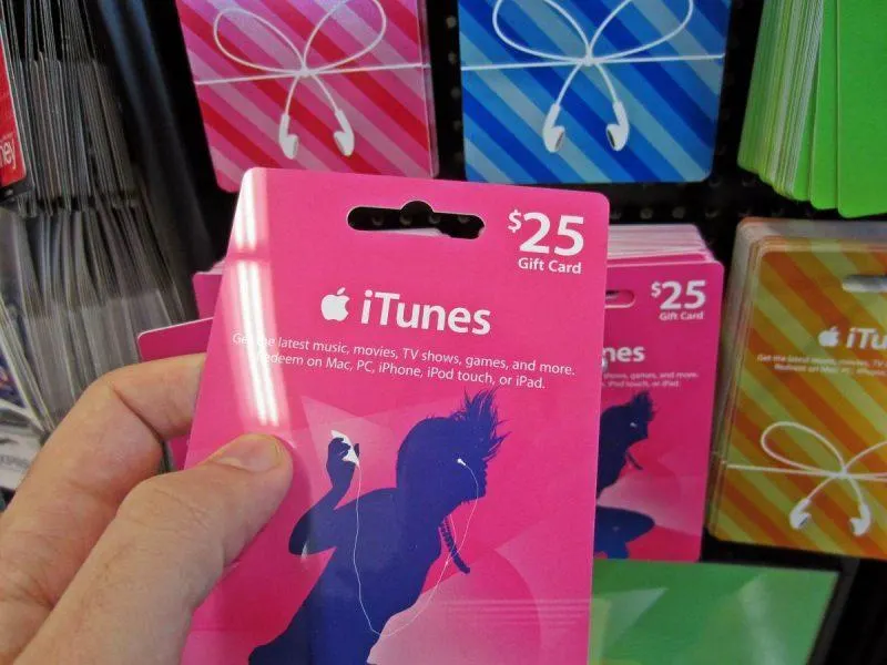 Person holding an iTunes gift card