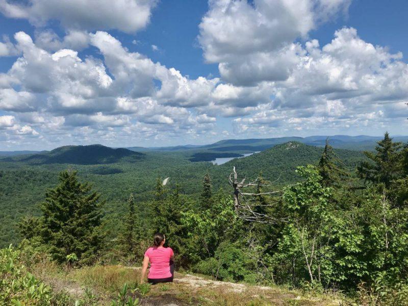 Girl seated on top of a mountain