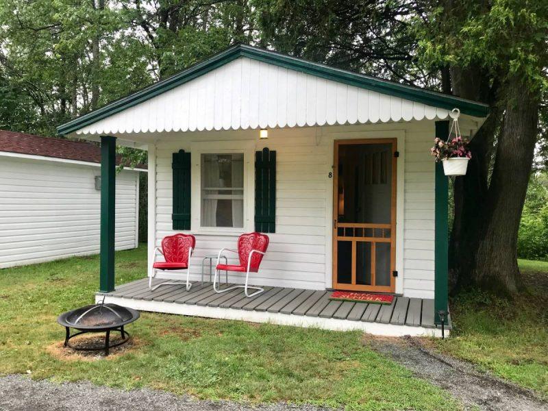 Charming cabin with chairs and fire pit out front