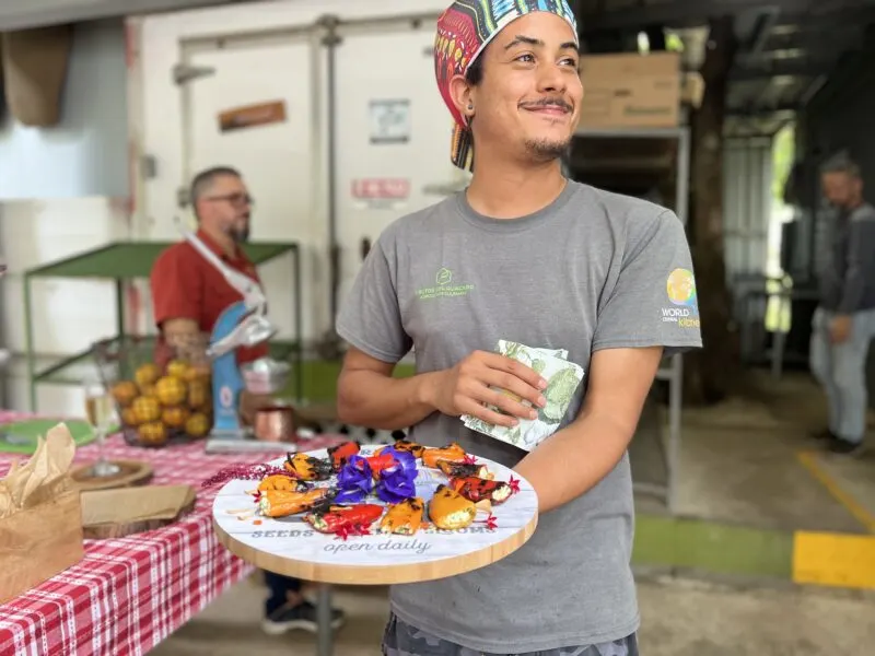 Man holding tray of peppers stuffed with goat cheese