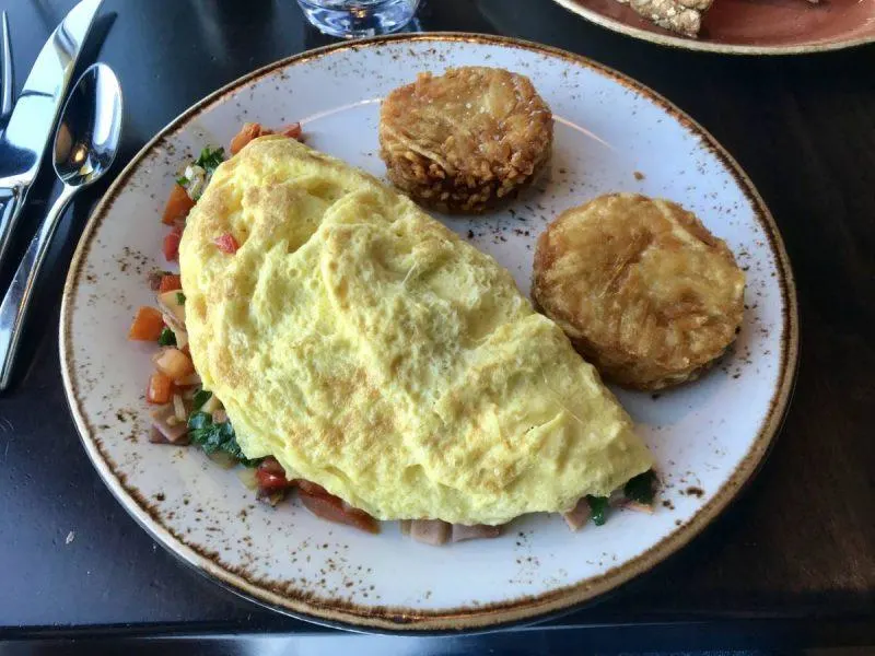 Eggs and hash browns on a plate like a happy face