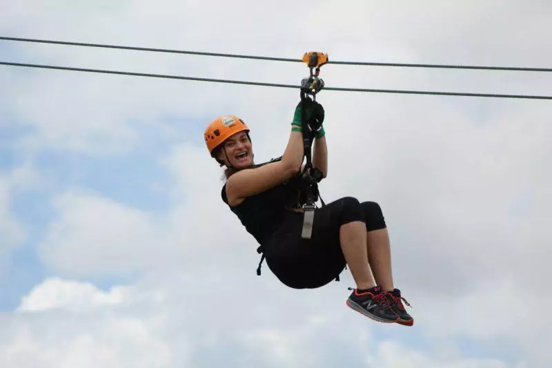 Woman smiling while riding a zipline