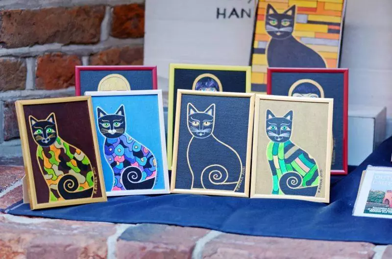 Paintings of cats on display