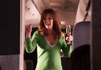 Holding champagne and dancing on the plane