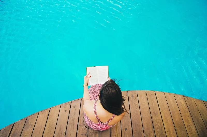 Woman reading by the pool