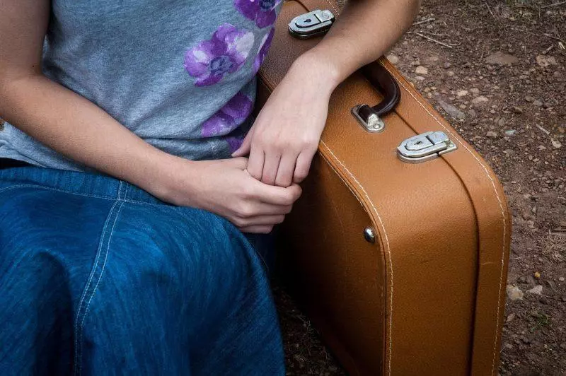 Woman sitting next to luggage