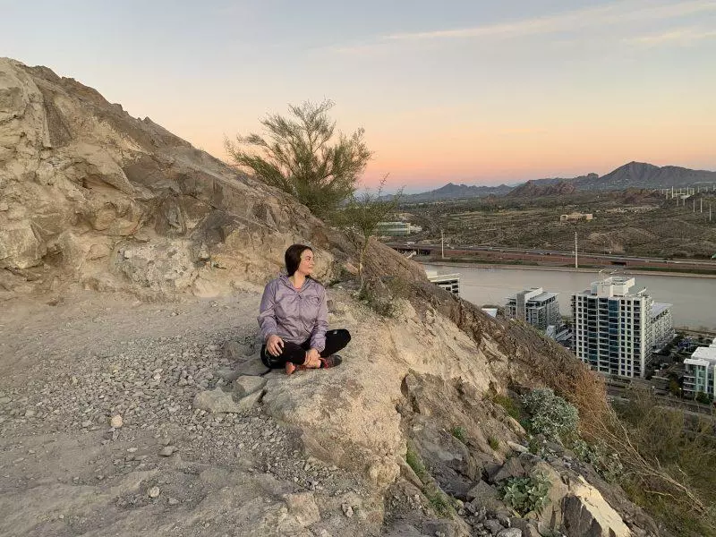 Woman sitting at the peak of "A" Mountain