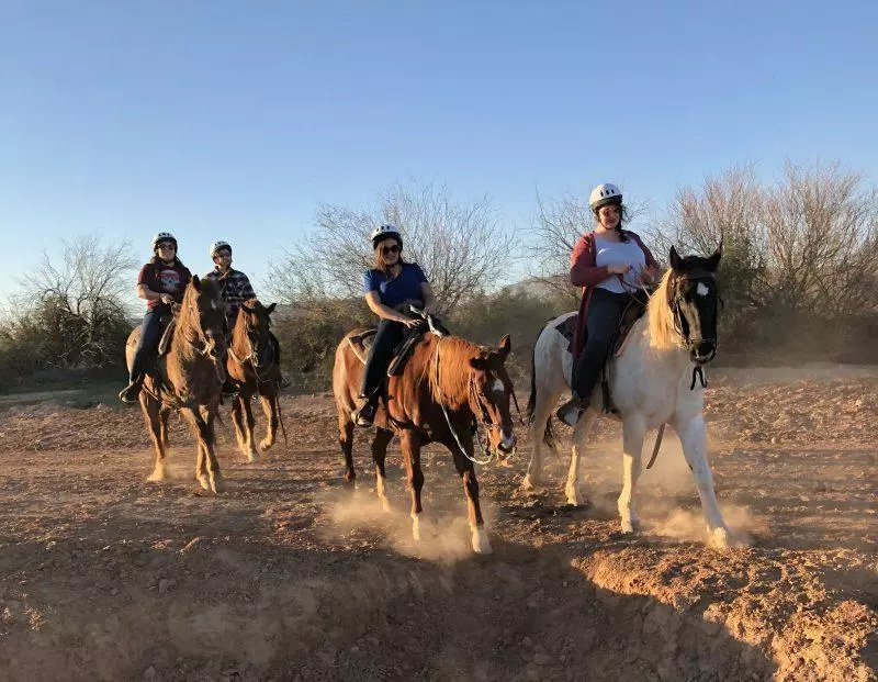 group of people riding horses