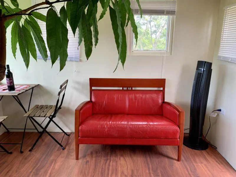 Red loveseat and dining area