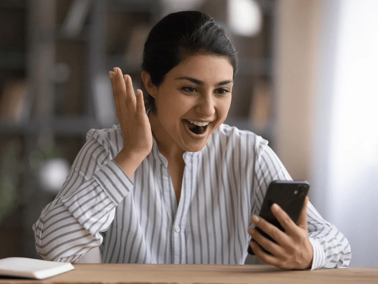 Woman excitedly looking at phone
