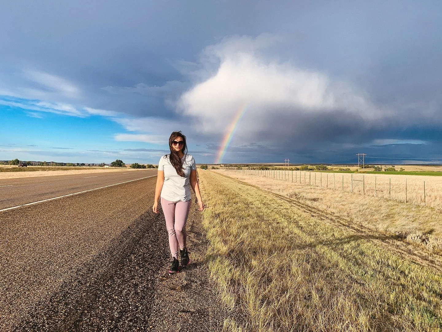 Walking roadside with a rainbow in background