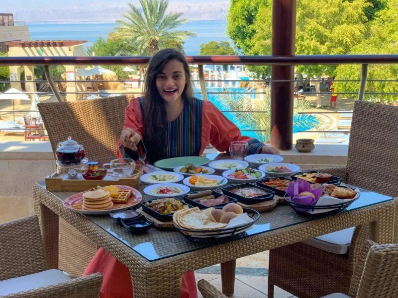 Woman sitting at breakfast table filled with food