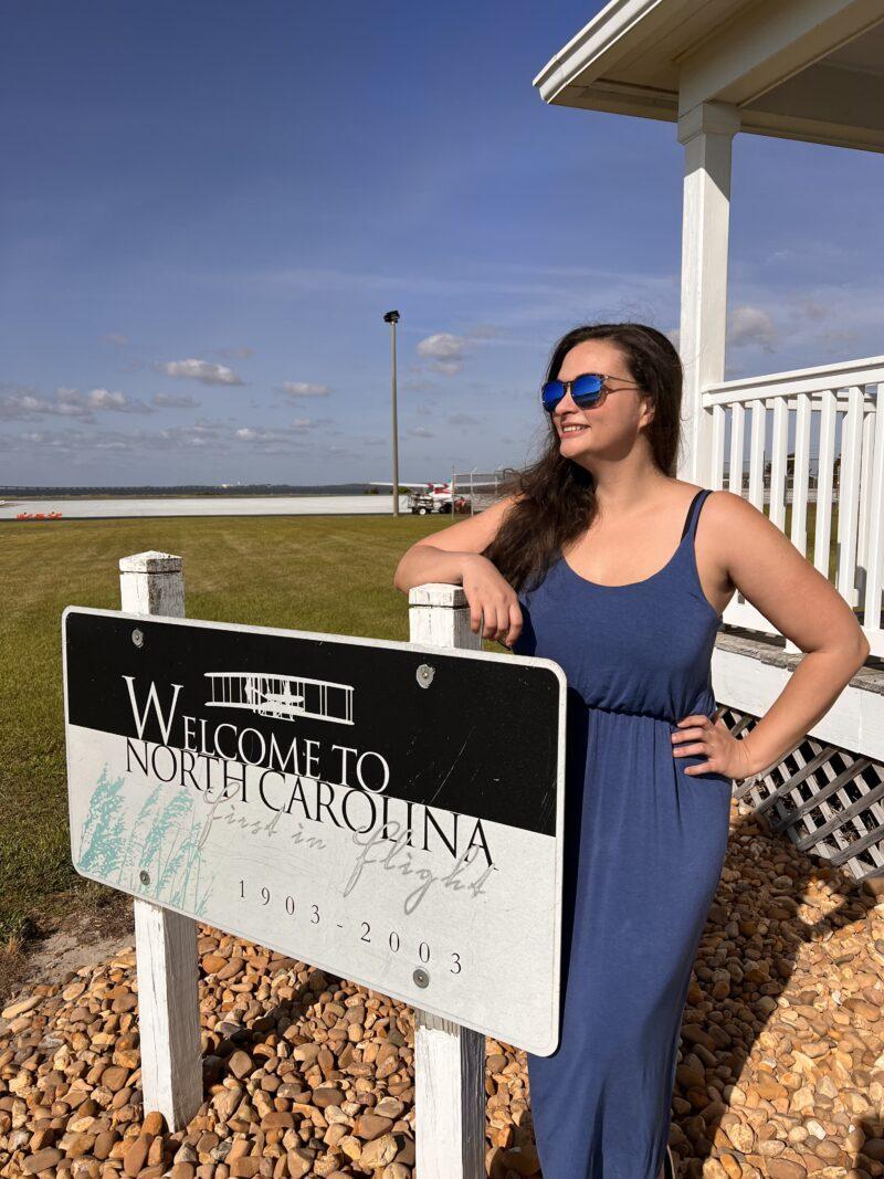 Woman standing by North Carolina sign