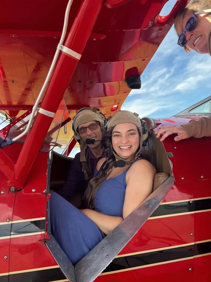 Man and woman sitting in cockpit of biplane