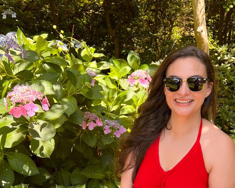 Woman in red dress sitting in garden