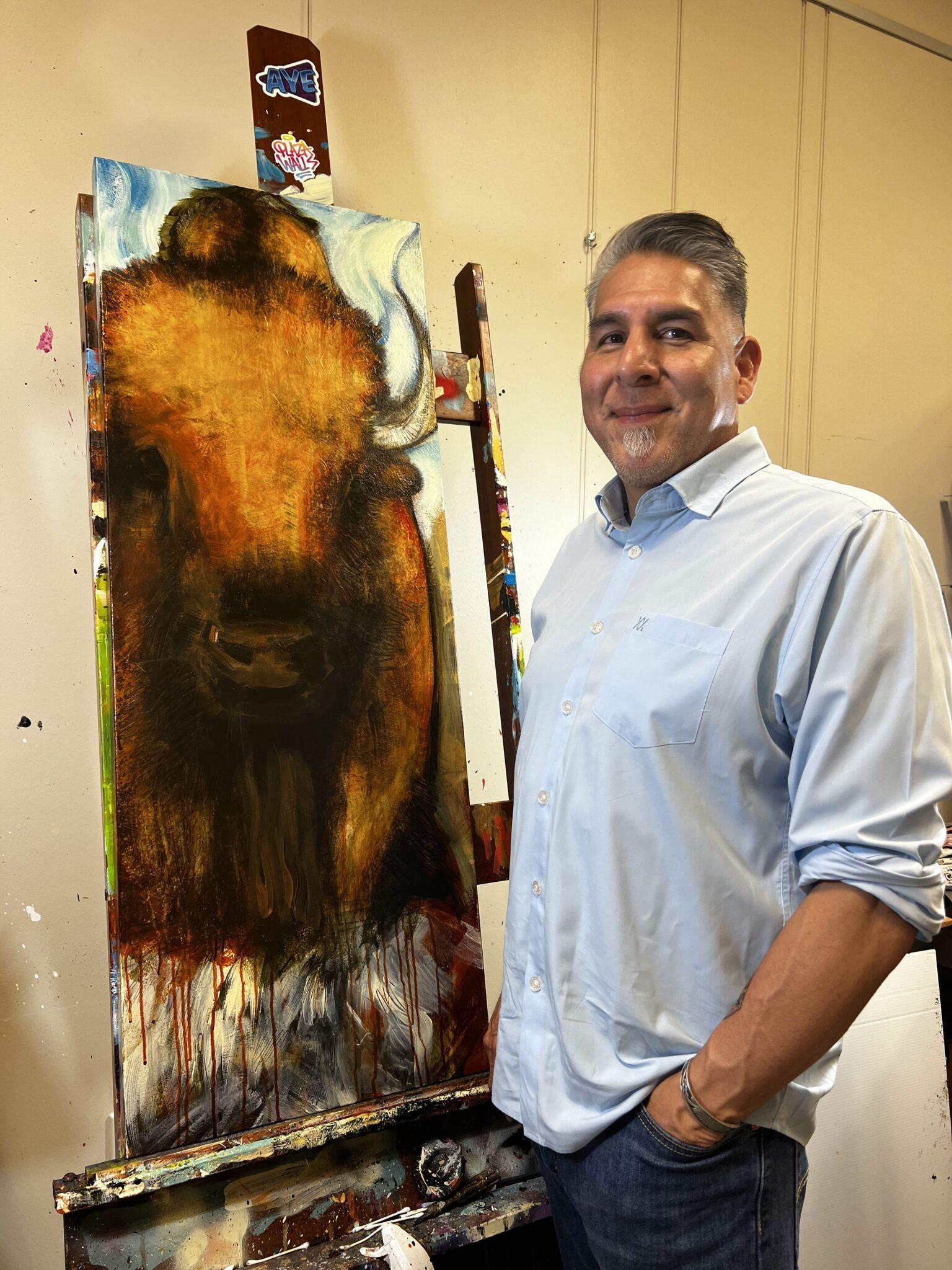 Man standing in front of buffalo painting