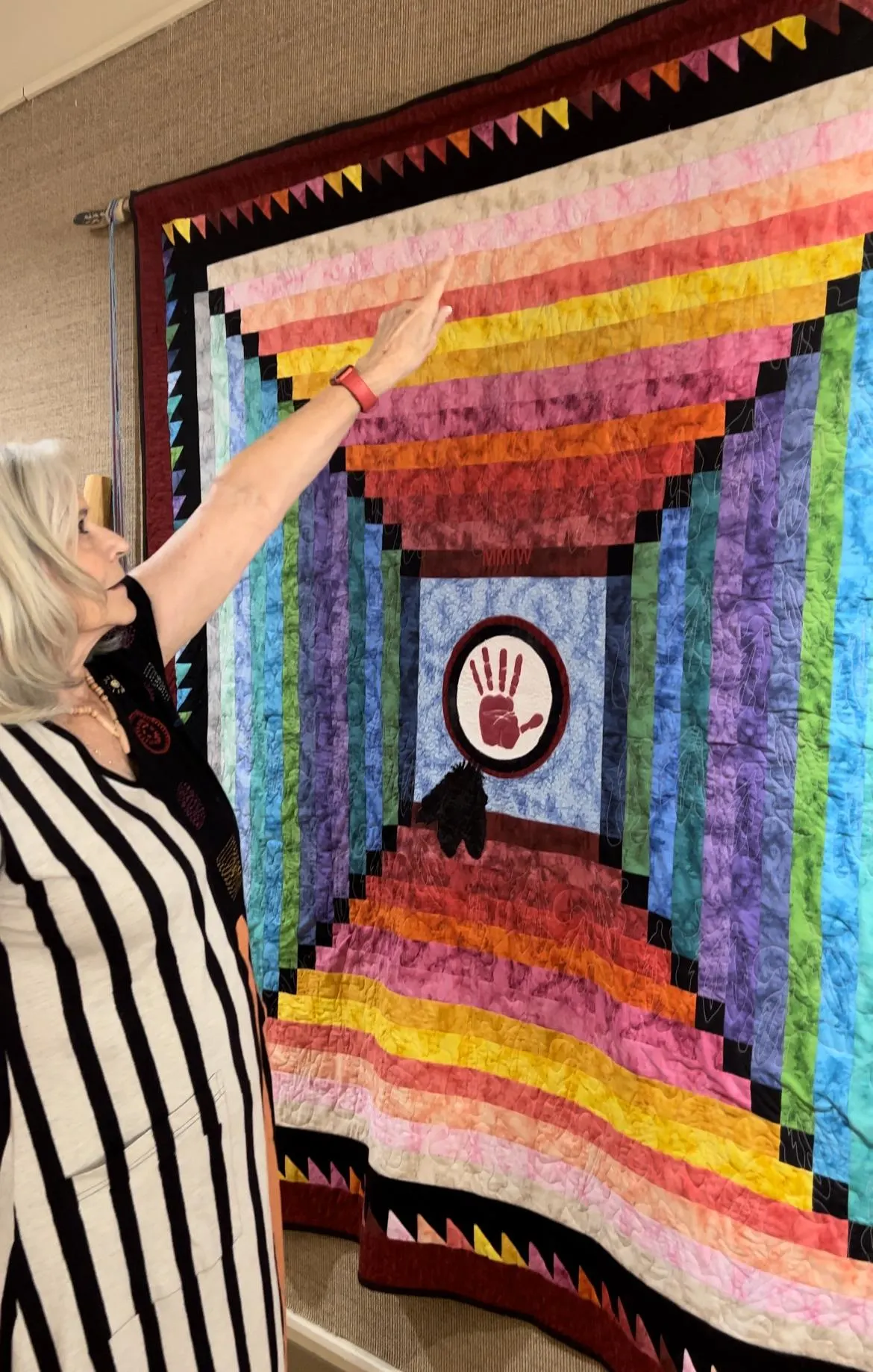 Woman pointing at colorful quilt