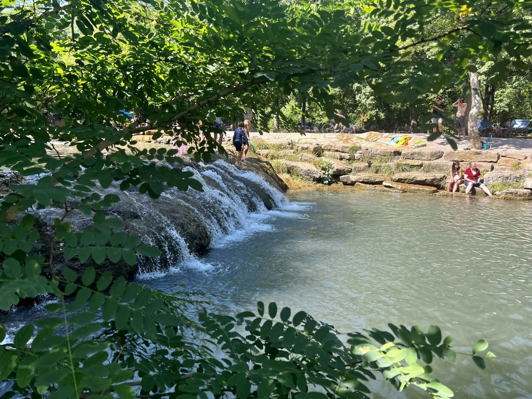 Children playing by a small waterfall