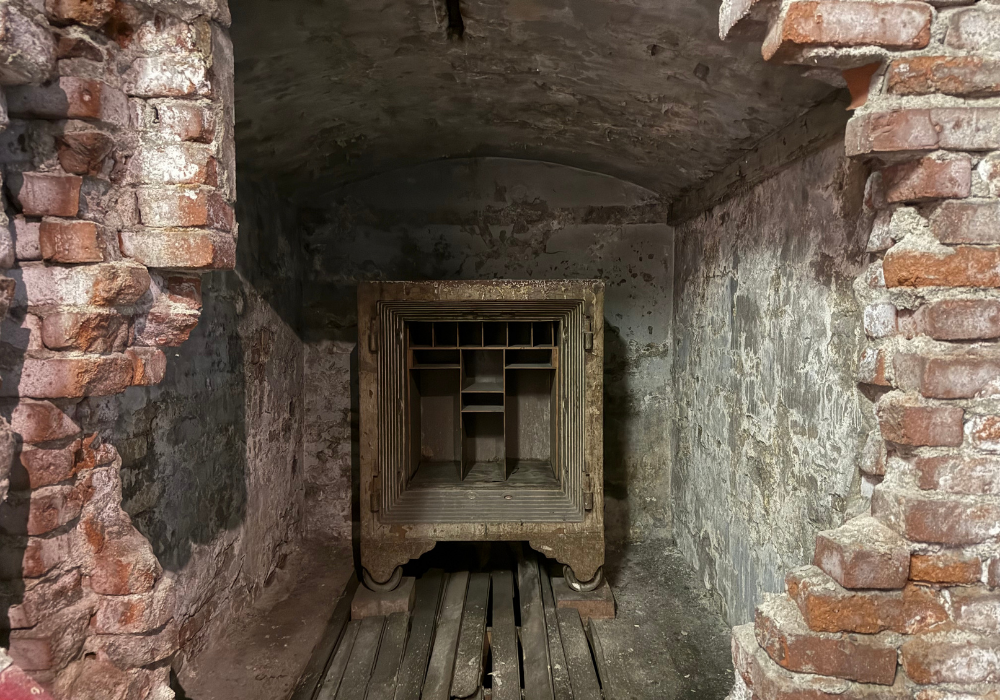 Metal safe with no door behind exposed and crumbled bricks