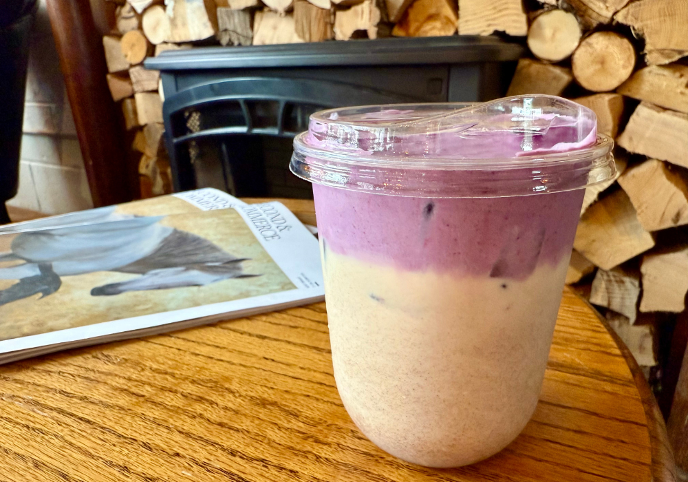 Lavender foam topped chai latte in plastic cup