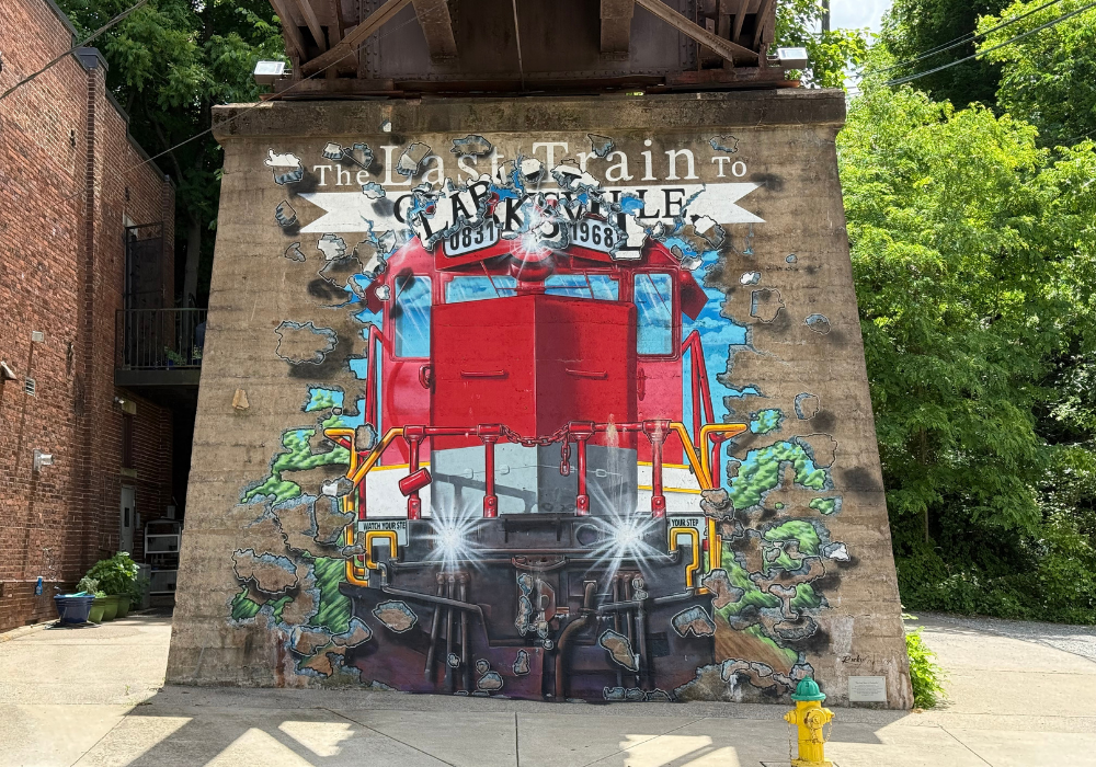 Mural of train bursting through brick