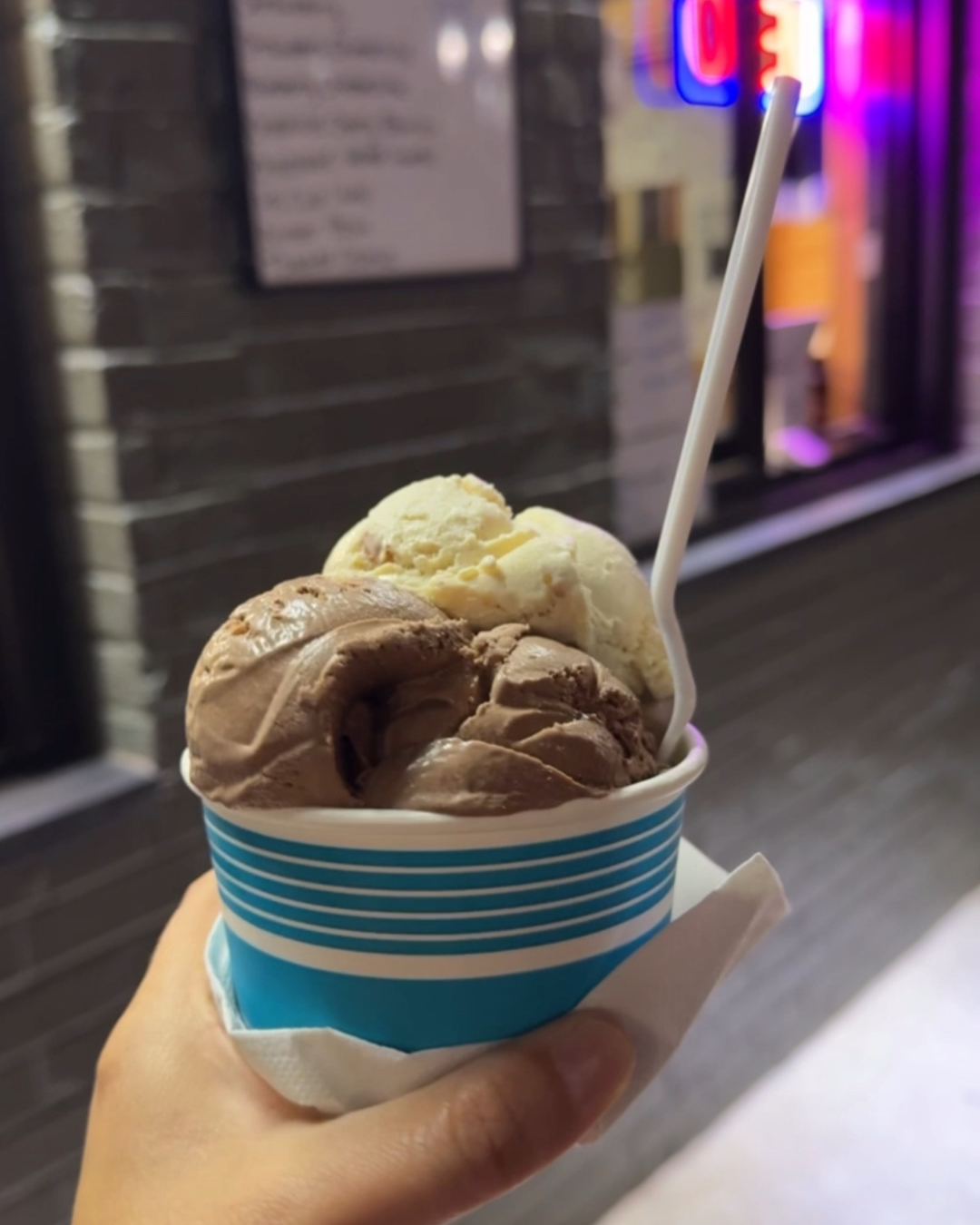 Ice cream with two scoops and plastic spoon in cup