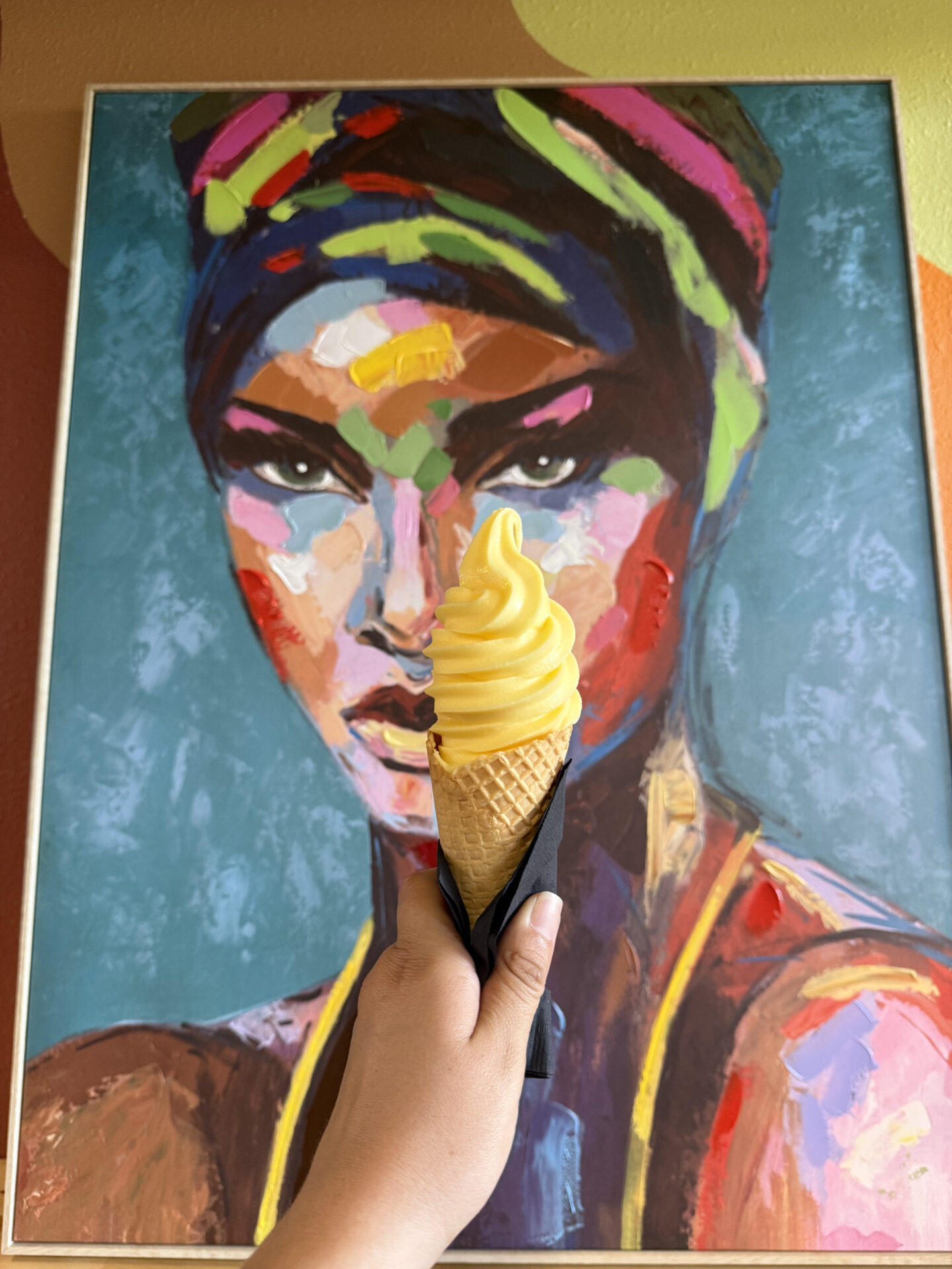 Ice cream held in front of painting