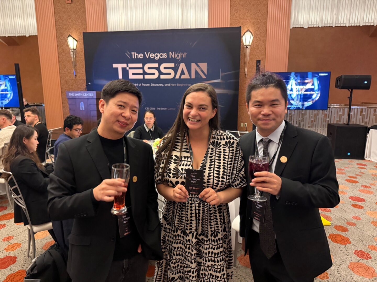 Two men and a woman smiling in attendance at the event