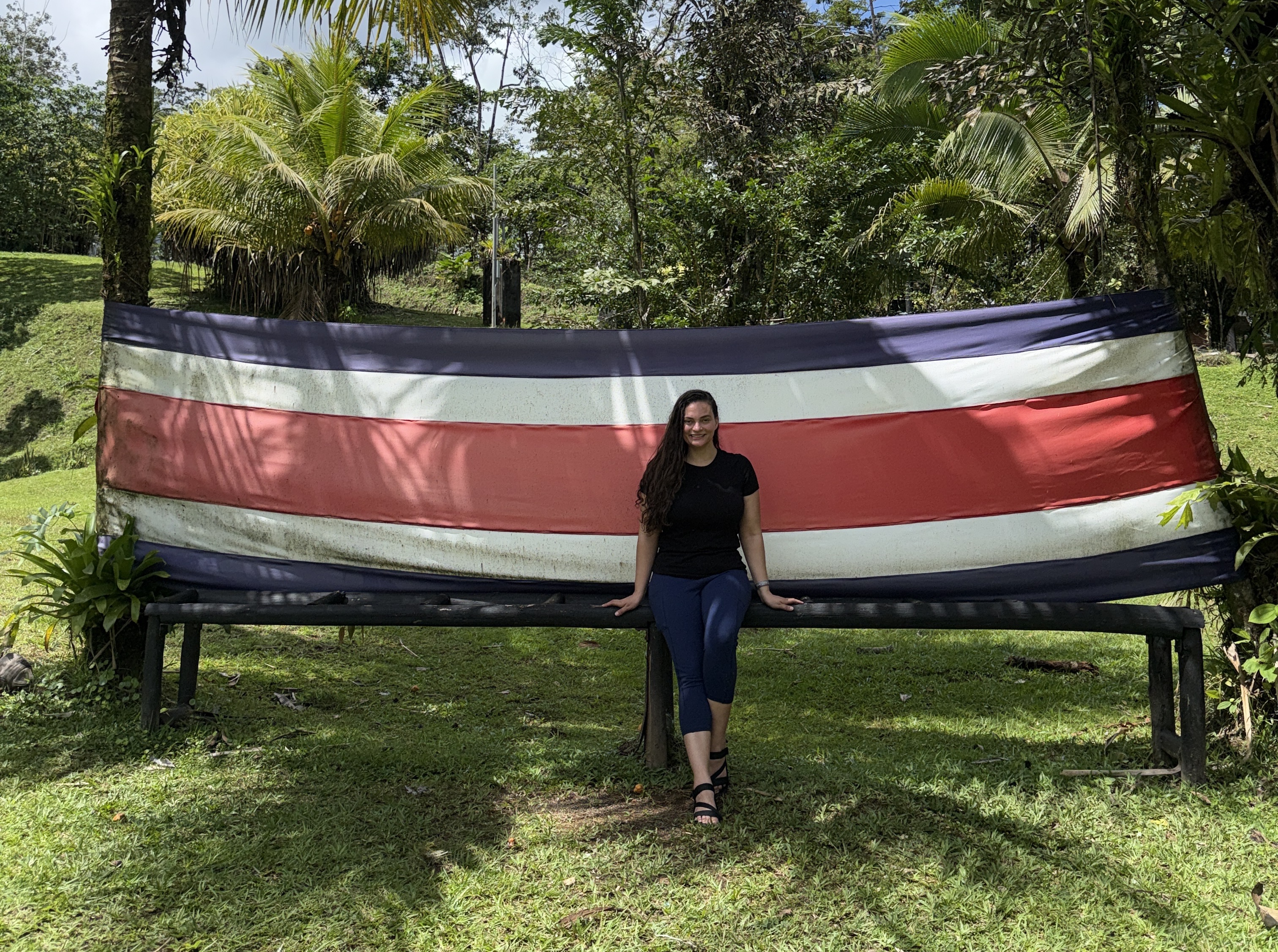 Woman sitting on bench that looks like a Costa Rican flag