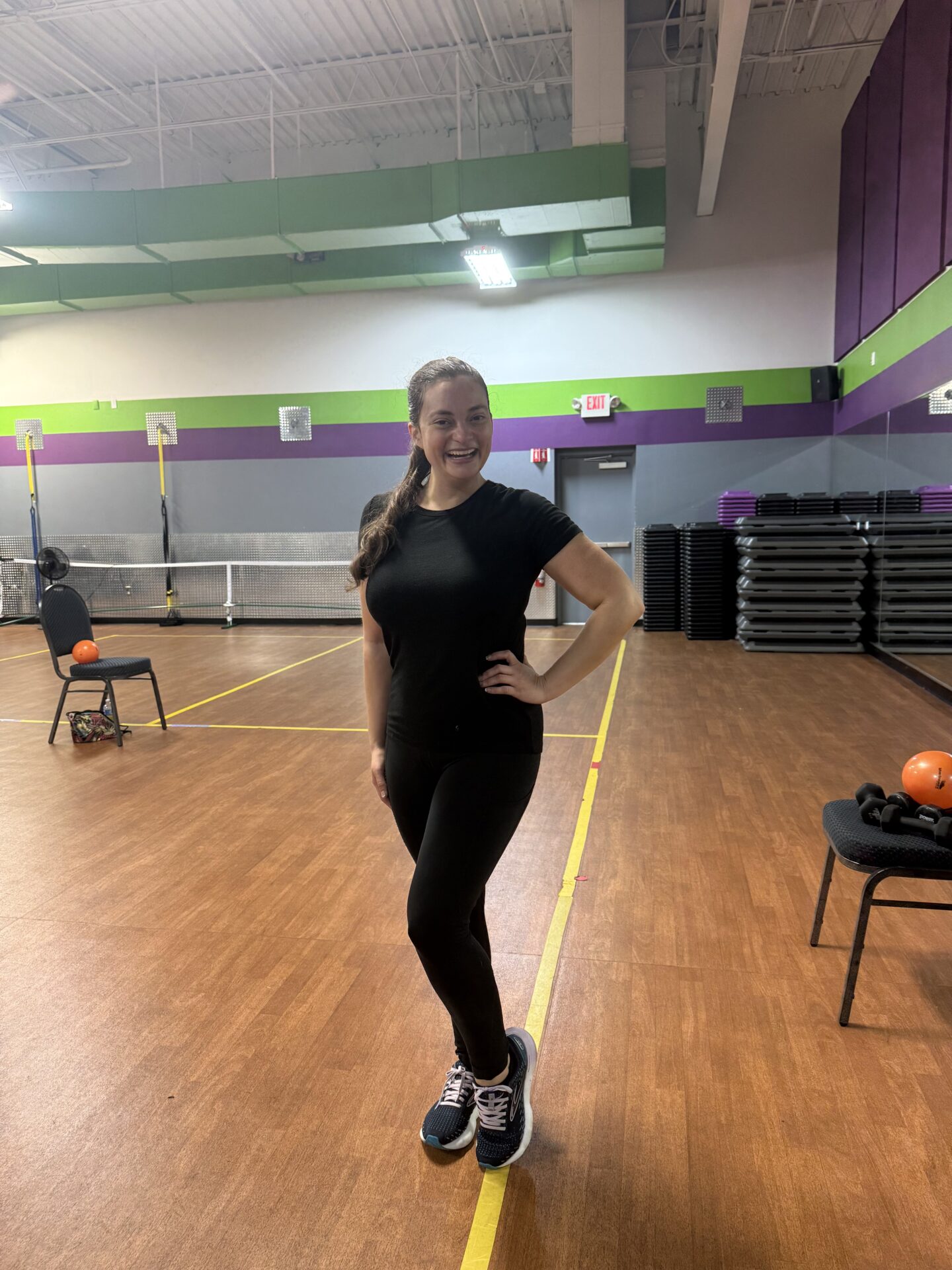 Woman standing in gym with hand on hip