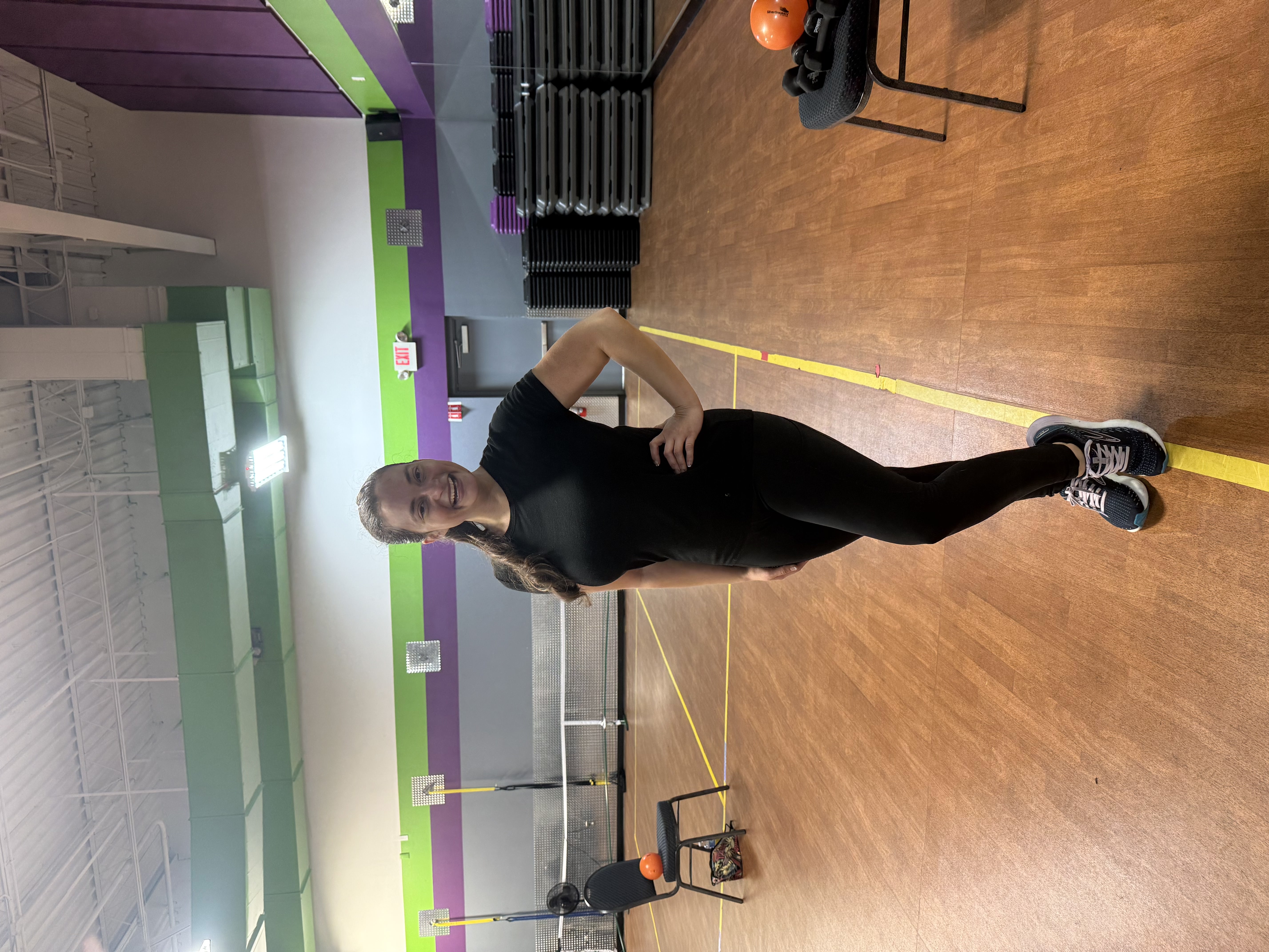 Woman standing in gym with hand on hip