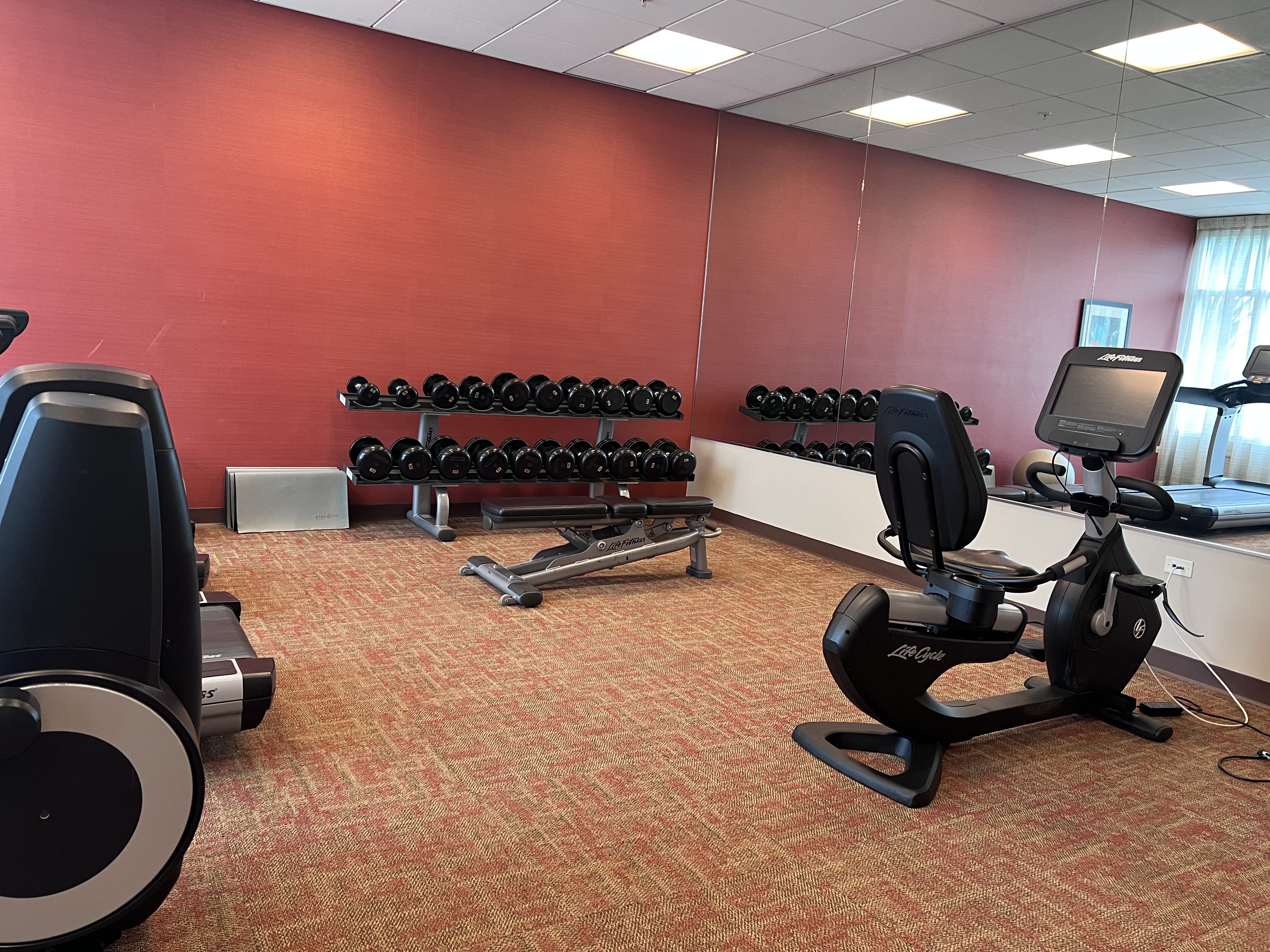 gym with red wall and workout machines
