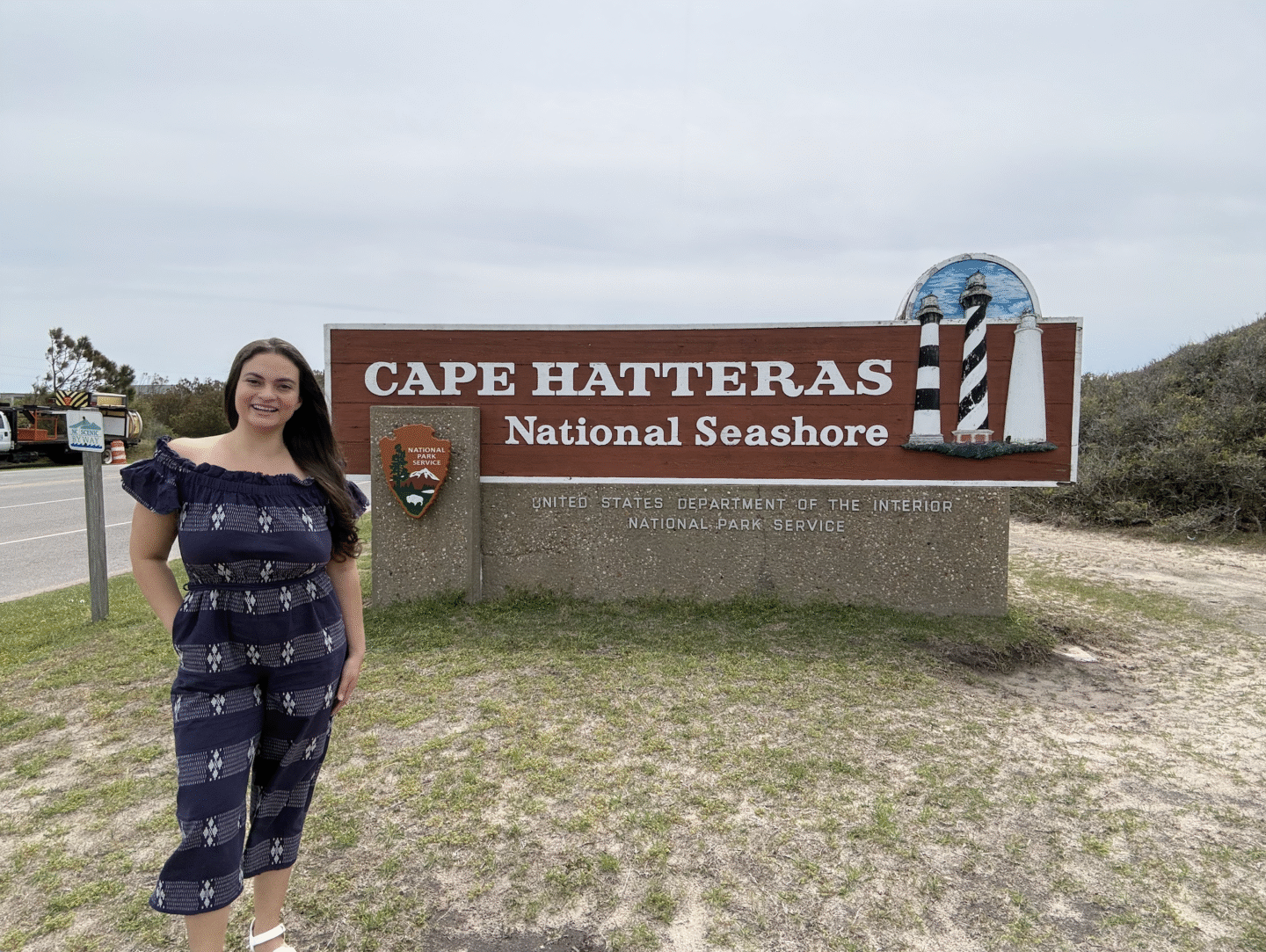 Woman standing in front of Cape Hatteras sign