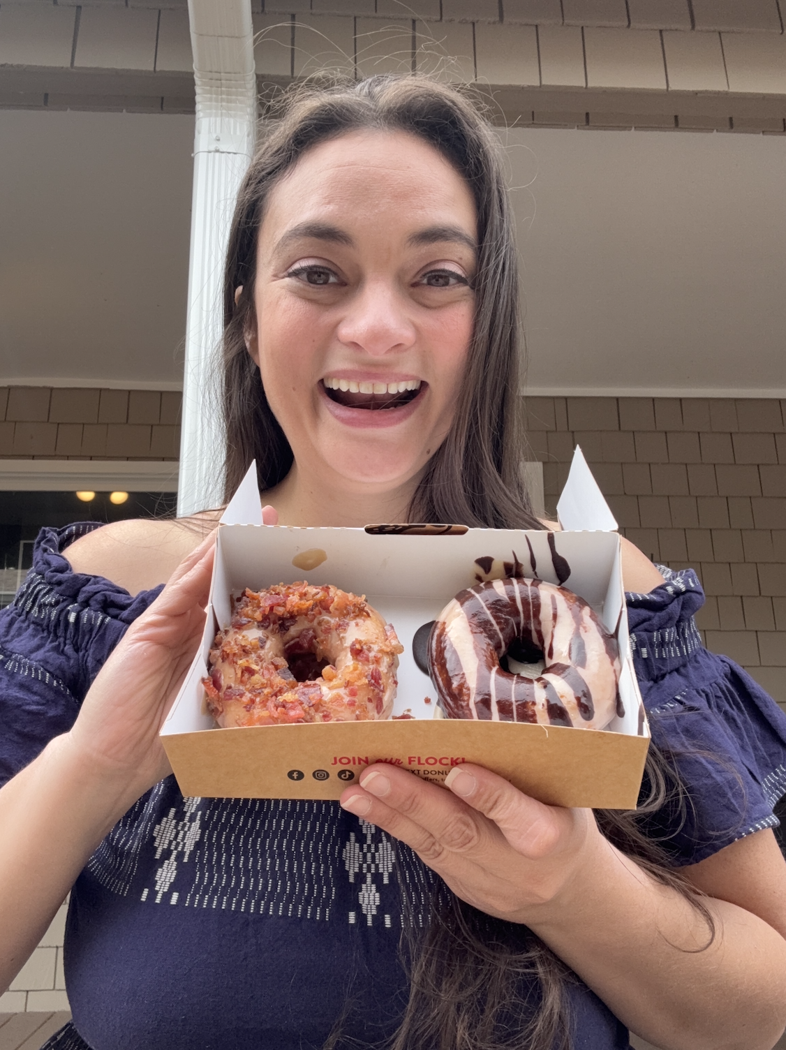 Woman holding two donuts in box