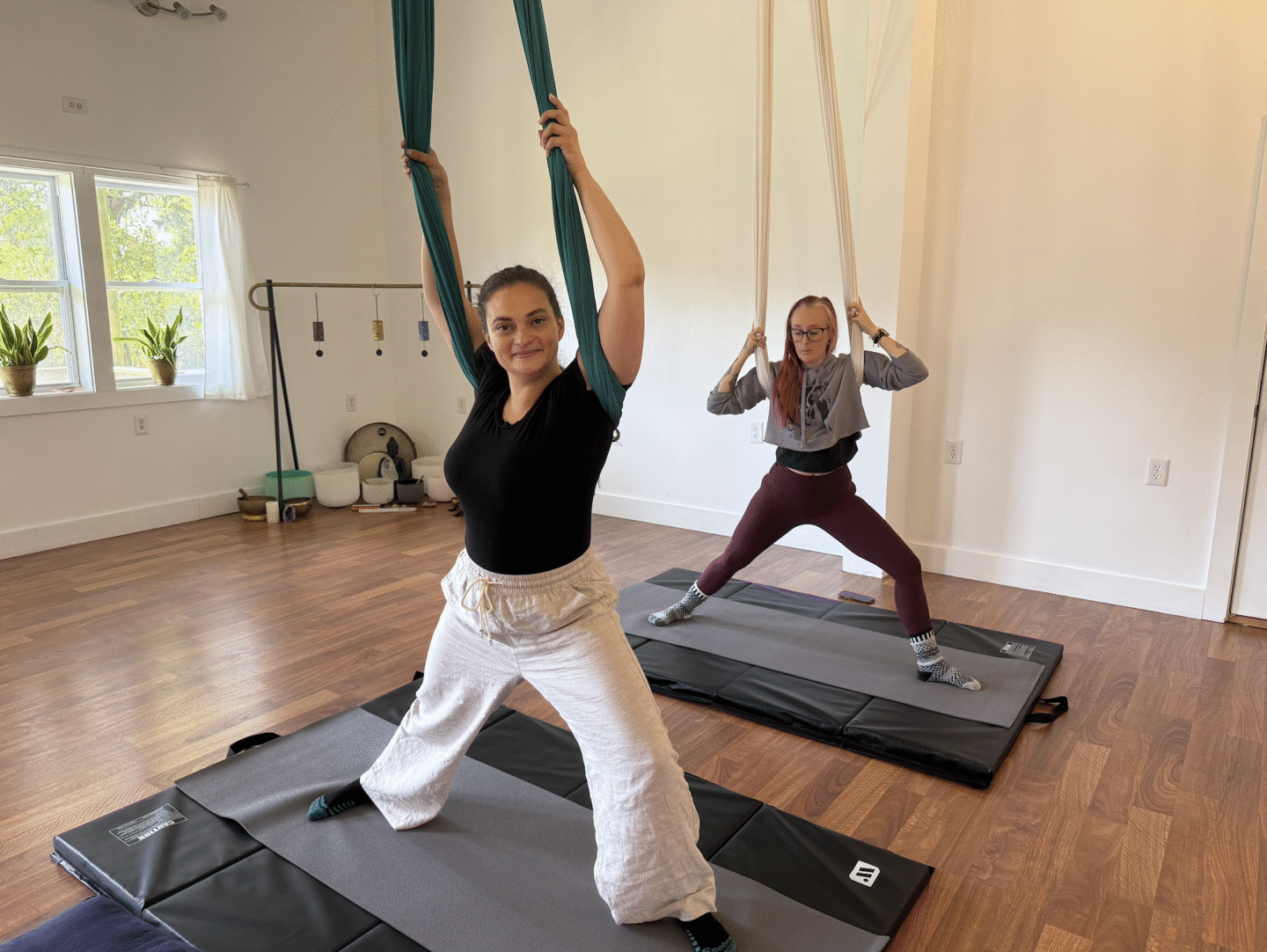 Two women doing aerial yoga